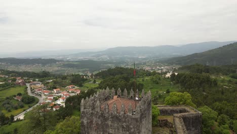 Aerial-view-of-Castelo-de-Lanhoso-with-lush-valleys-and-distant-mountains-in-Portugal