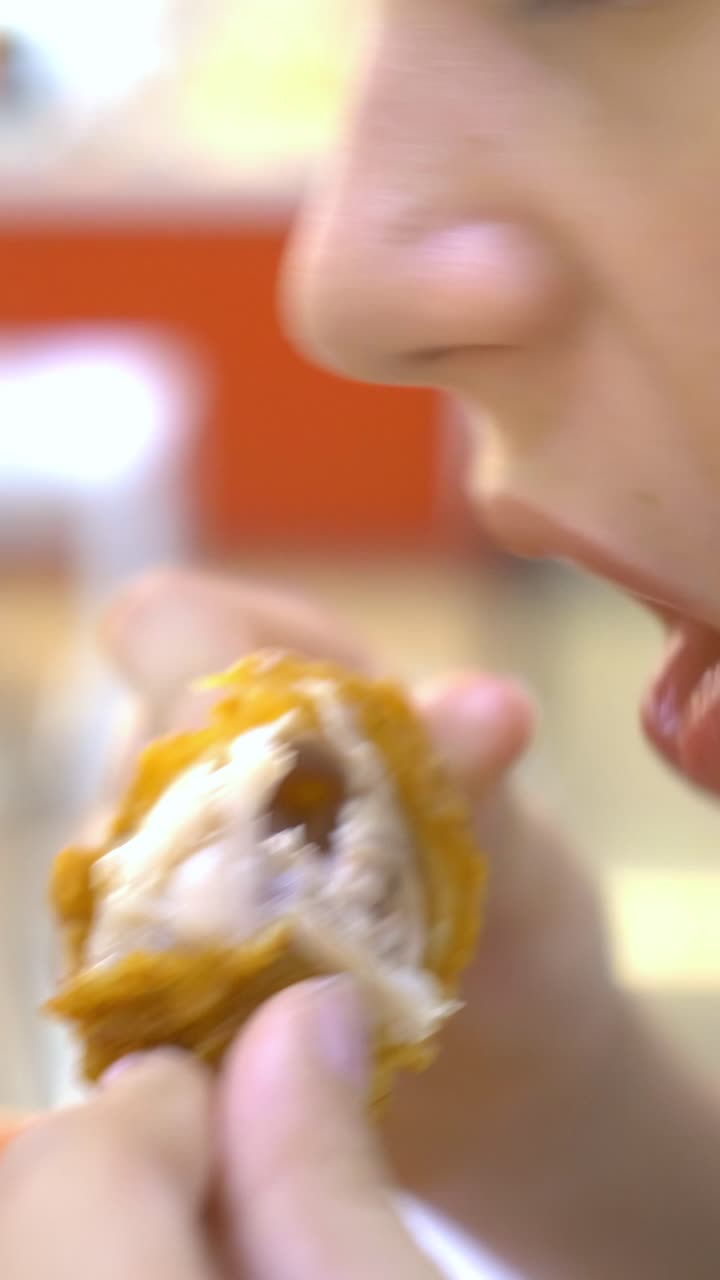 Close-up of someone eating a piece of fried chicken