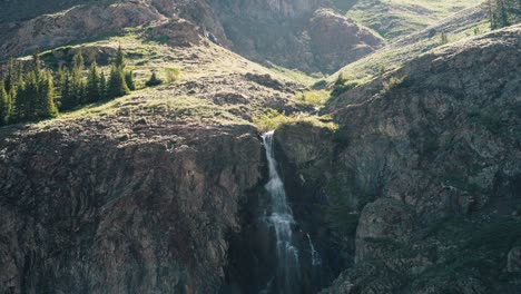 aerial shot of a river falling down a mountain in the san juan range in colorado.