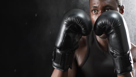 african american boxer training intensely in the gym on a black background