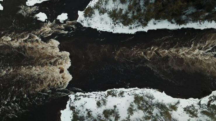 Ripresa dall'alto con drone di rapide di acqua bianca su un fiume canadese in inverno
