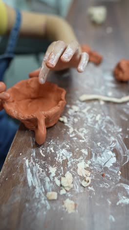 child making a clay bowl