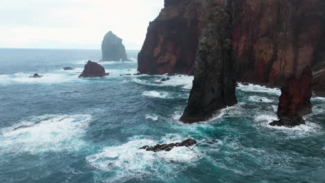 cliffs of red volcanic rock in ponta de sao lourenco, madeira, portugal - aerial drone shot