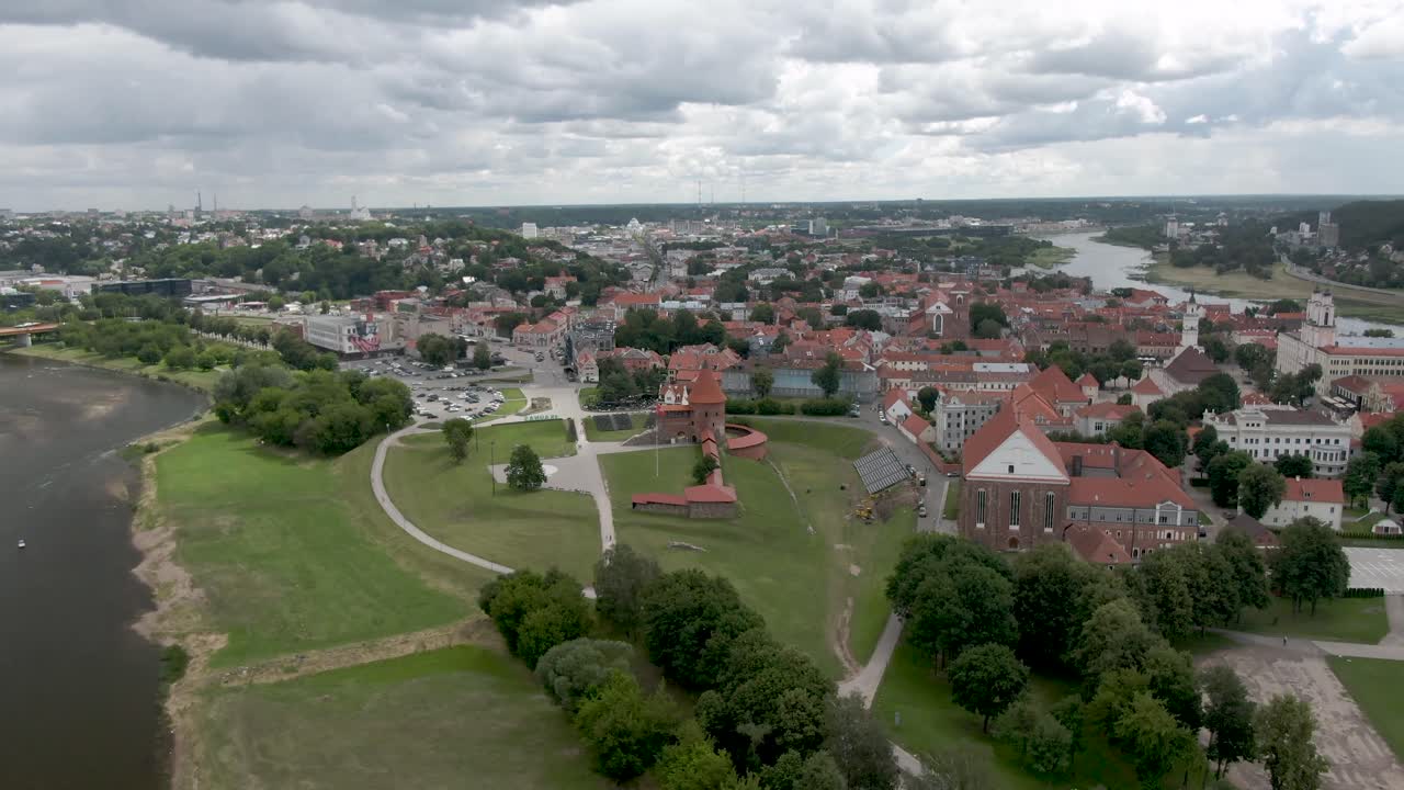 Aerial drone shot of castle far side view with city and river in the background. City panorama