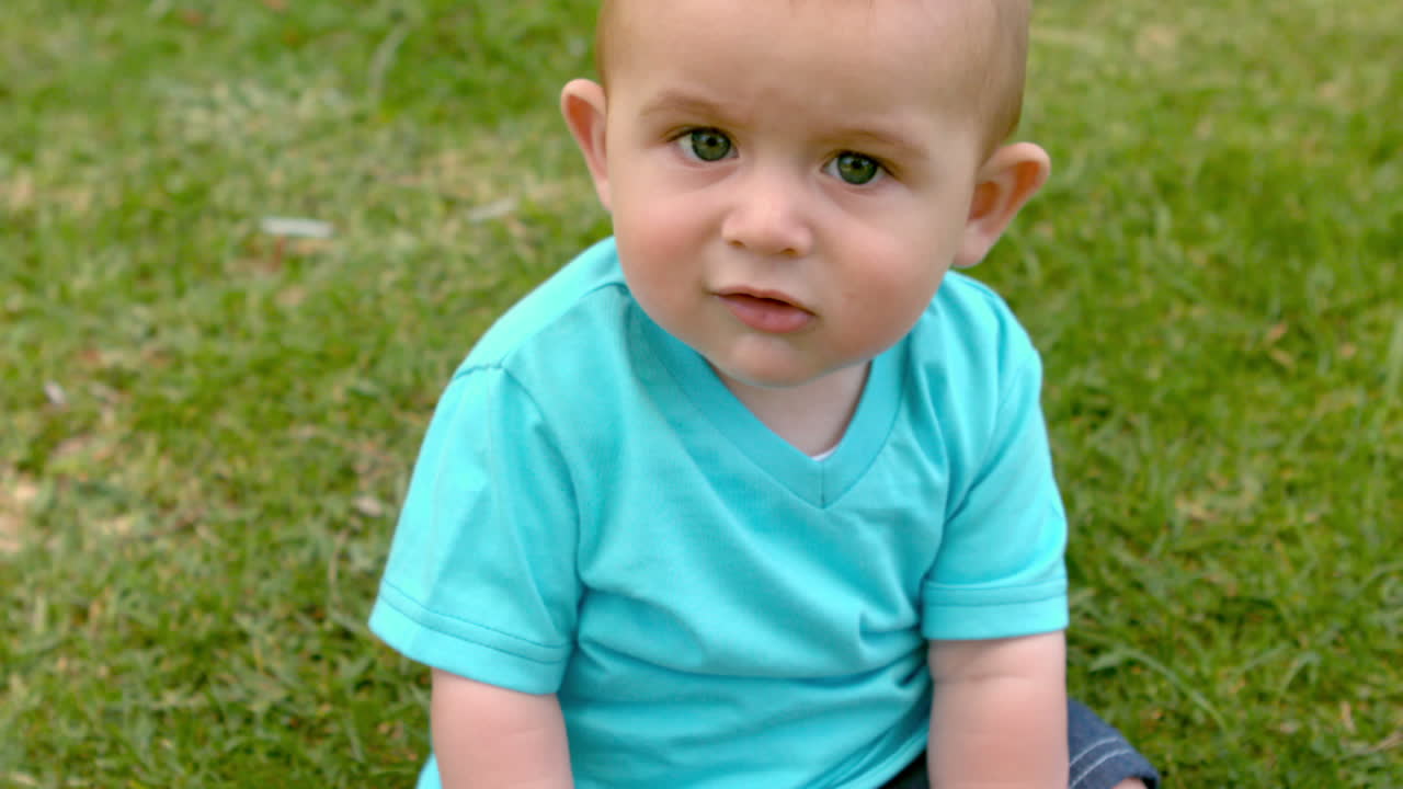 Bambino carino seduto sull'erba