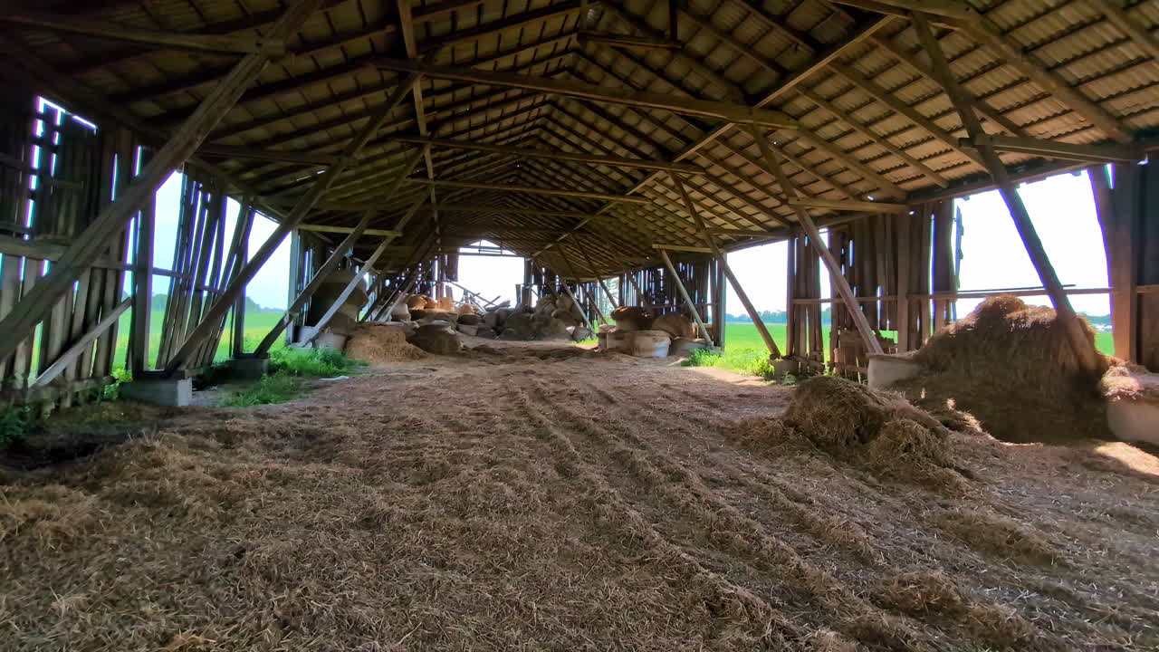 Old barn with leftover of hay after winter, panoramic view