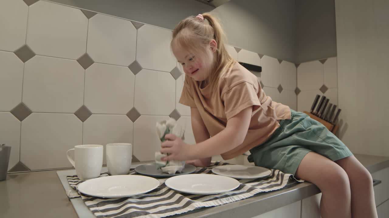 Girl with Down Syndrome Cleaning Dishes in Kitchen