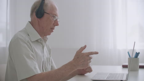 aged professor is explaining to pupils lecture communicating online by webinar and video call sitting at home