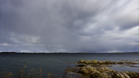 heavy storm clouds approaching the rocky seashore