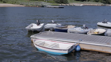 boats tied to a dock at a lake gently rock in the waves