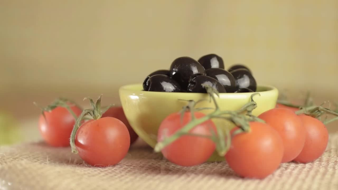 Black olives and cherry vine tomatoes rotating medium shot