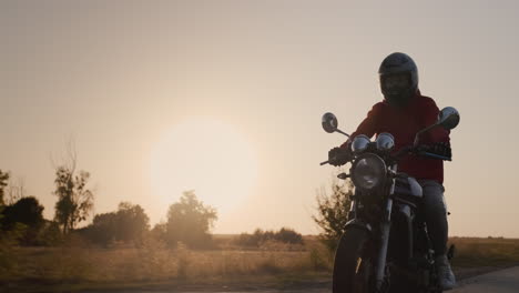 Motorcyclist-rides-on-a-country-road-at-sunset