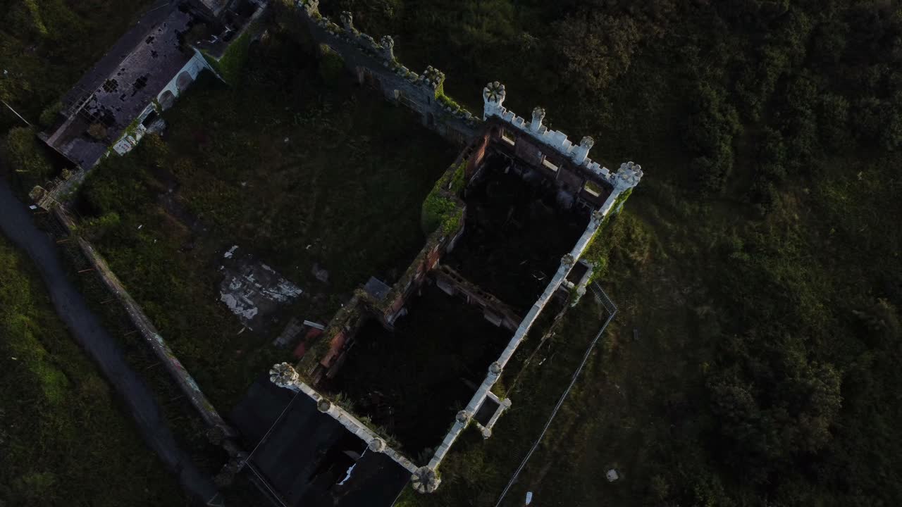 los soldados apuntan a la casa del castillo vista aérea del ojo de pájaro dando vueltas abandonada cubierta de vegetación mansión de holyhead