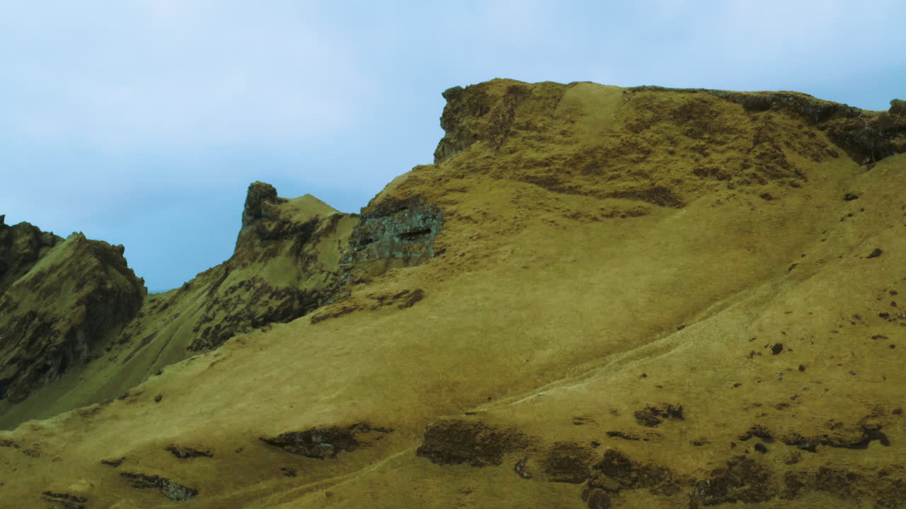 Splendida veduta aerea di montagne rocciose verdi vicino a una scogliera. Ripresa aerea della bellezza delle montagne islandesi. Vista drone delle montagne in Islanda, paesaggio mozzafiato, luogo selvaggio.