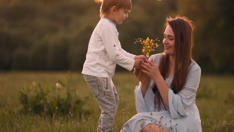 mother hugging her two sons in the sunset in the field. loving kids happy mom