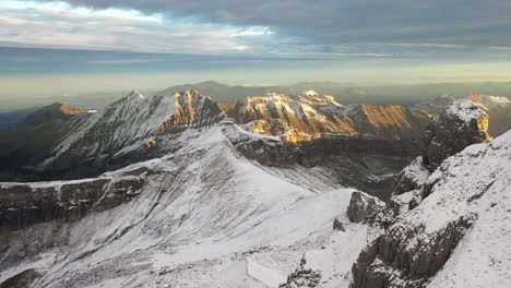 drone shot flying up and forward revealing the epic and dramatic landscape of the snow and ice covered mountains in the swiss alps