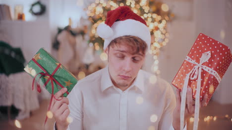 man shaking christmas presents while guessing gift at home