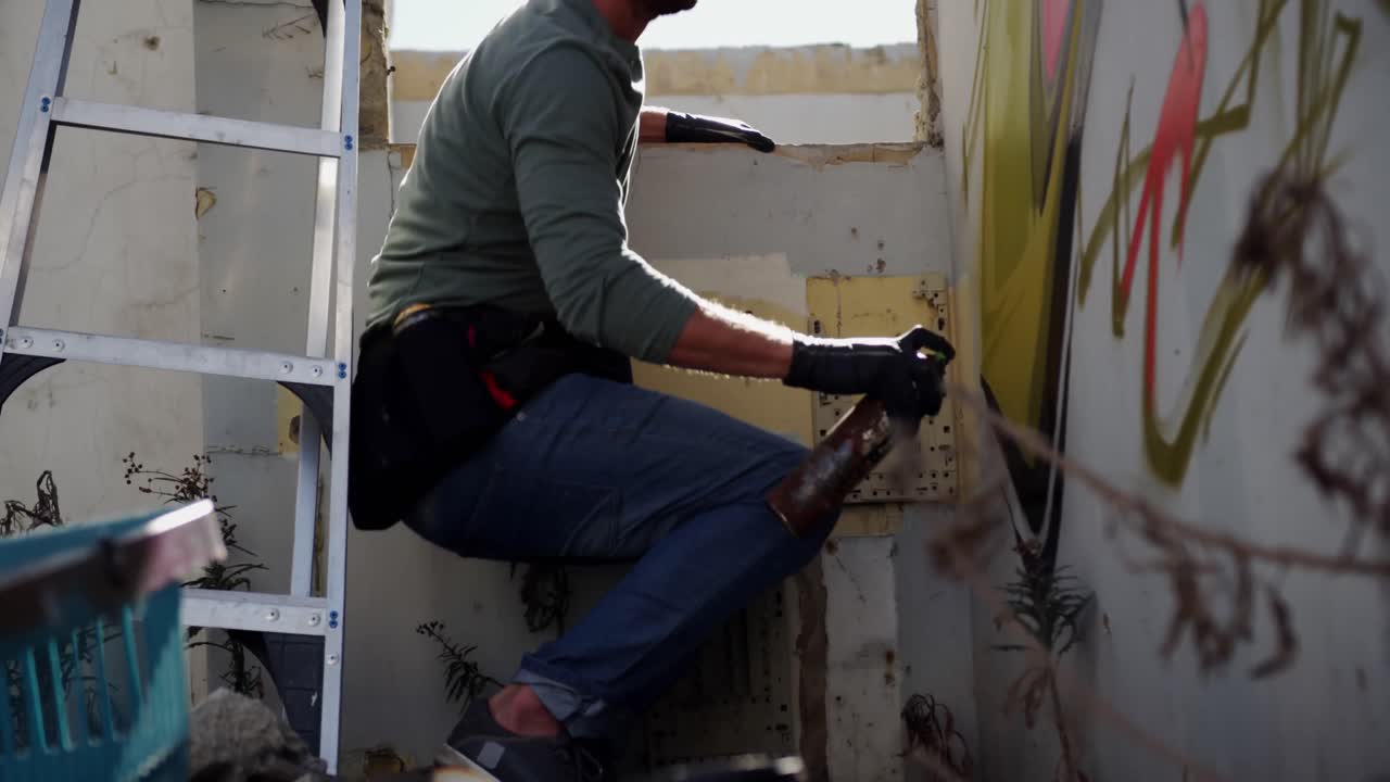 Graffitaro che dipinge con bomboletta spray sul muro 4k