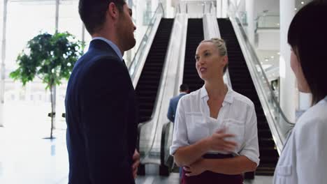 Business-people-interacting-with-each-other-in-the-lobby-at-office-4k