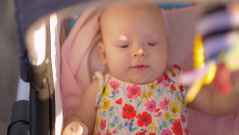 baby-mädchen beim spazierengehen im kinderwagen an einem sonnigen sommertag