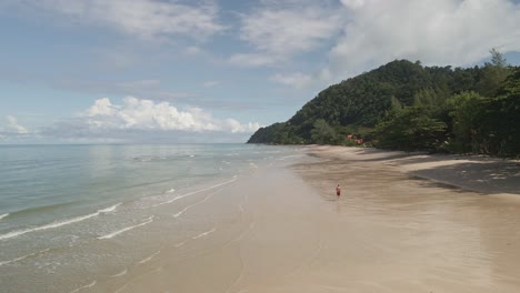 Vista-Aérea-De-ángulo-Bajo-Drone-Hombre-Corriendo-En-La-Playa-Tropical-En-La-Isla-De-Koh-Chang-En-Tailandia