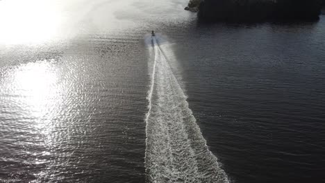 Alto-Vuelo-De-Drones-Detrás-De-Un-Jetsky-Que-Viaja-Sobre-El-Agua