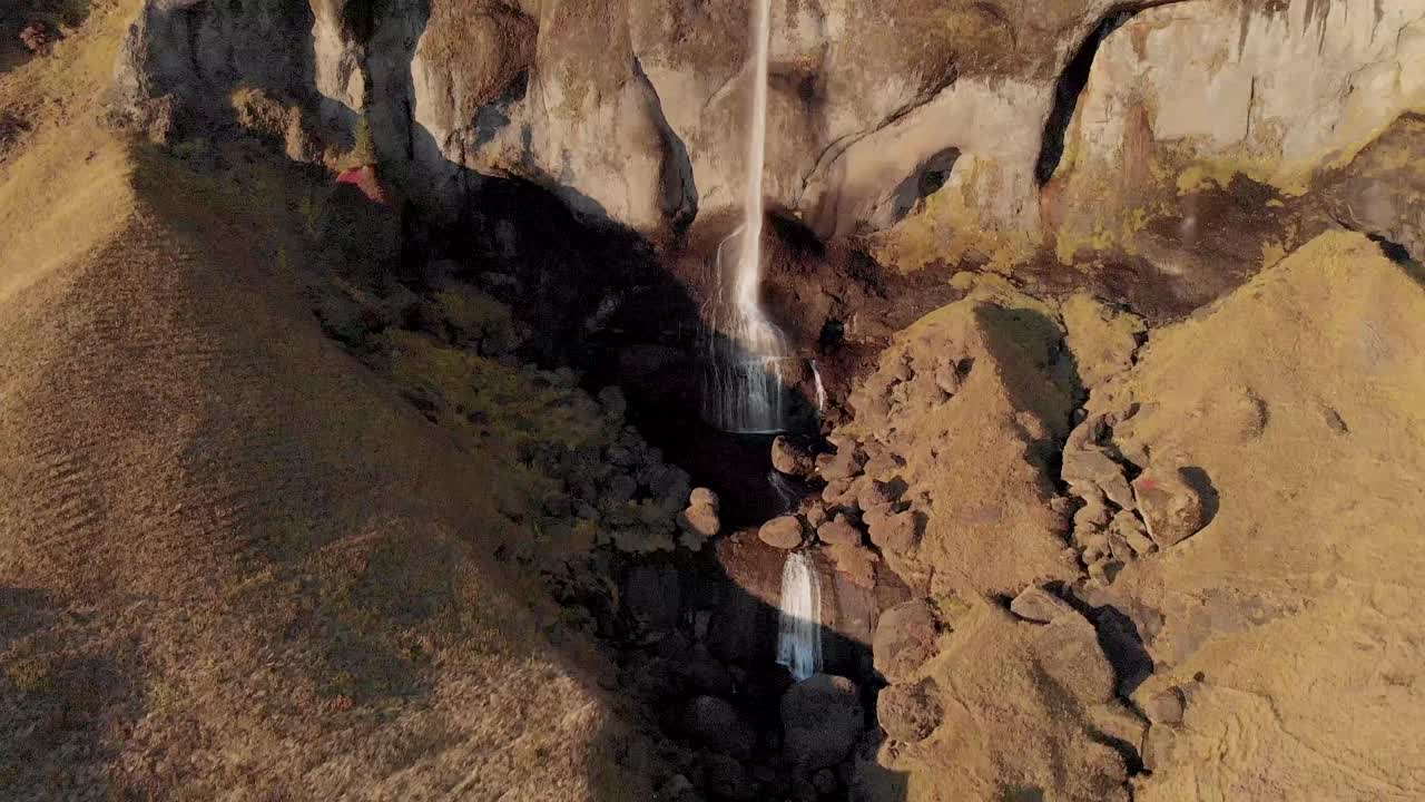 toma aérea panorámica hasta el arroyo debajo de una cascada alta