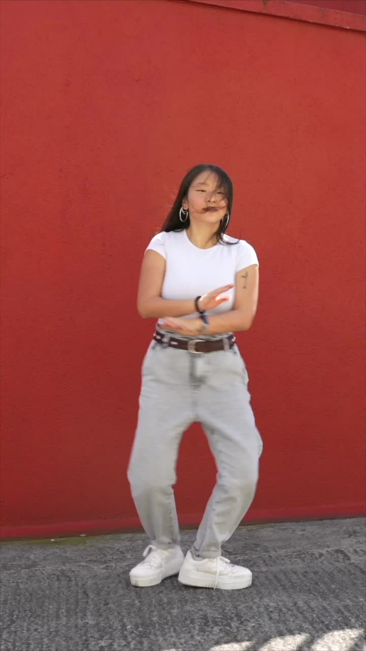 Woman dancing against a red background