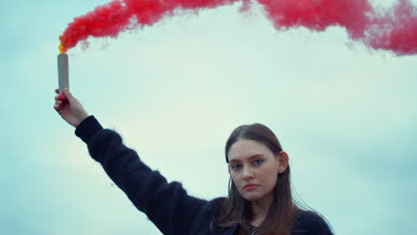chica con una bomba de humo en la mano en una protesta callejera. mujer usando una granada de humo