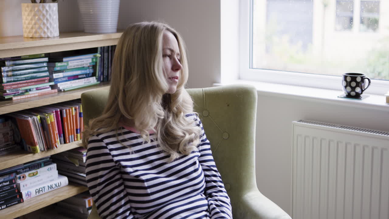 Kvinde med forkølelse siddende i en stol