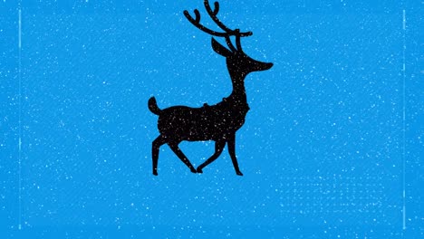 Snow-falling-over-silhouette-of-reindeer-walking-against-blue-background