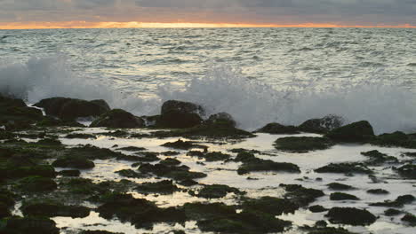 northsea waves hitting a dyke at sunset