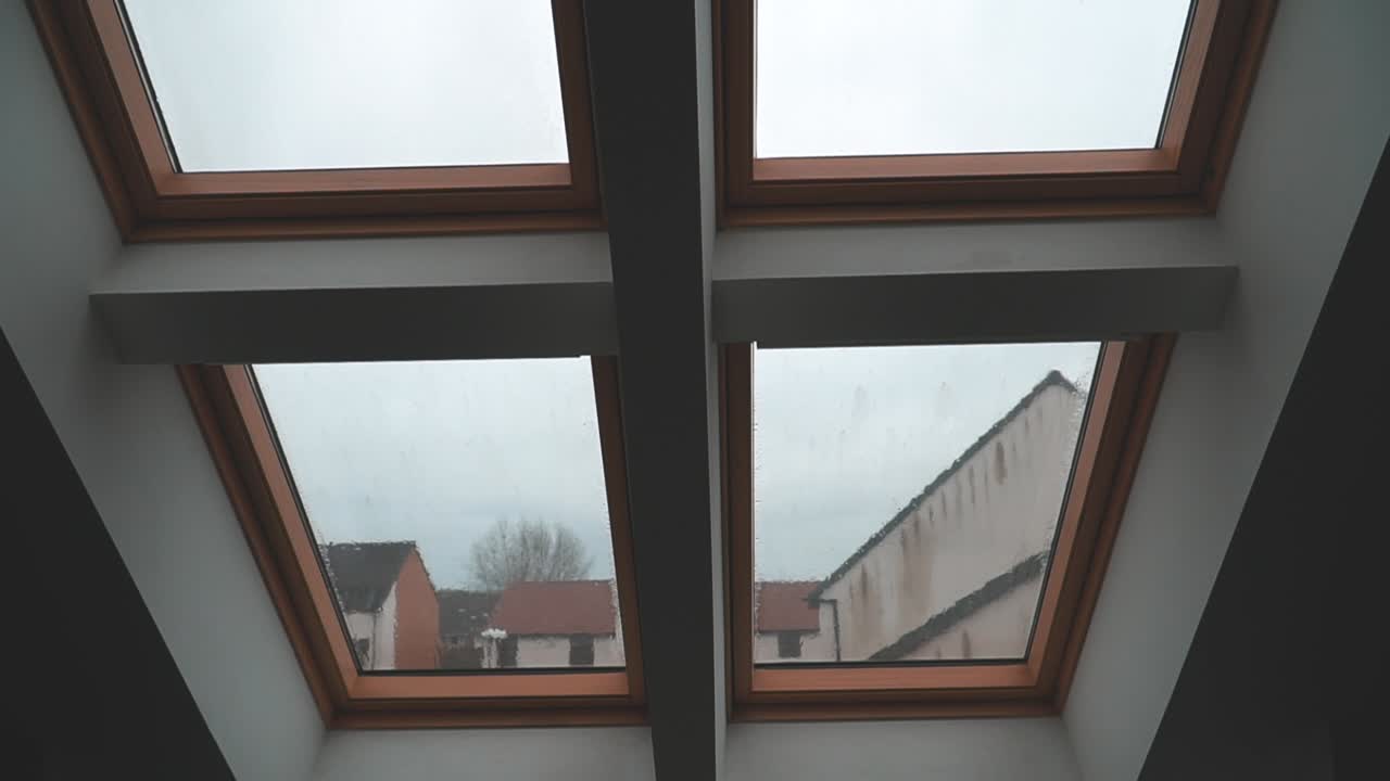 lapso de tiempo de lluvia cayendo sobre una ventana de loft en un día húmedo y nublado en inglaterra