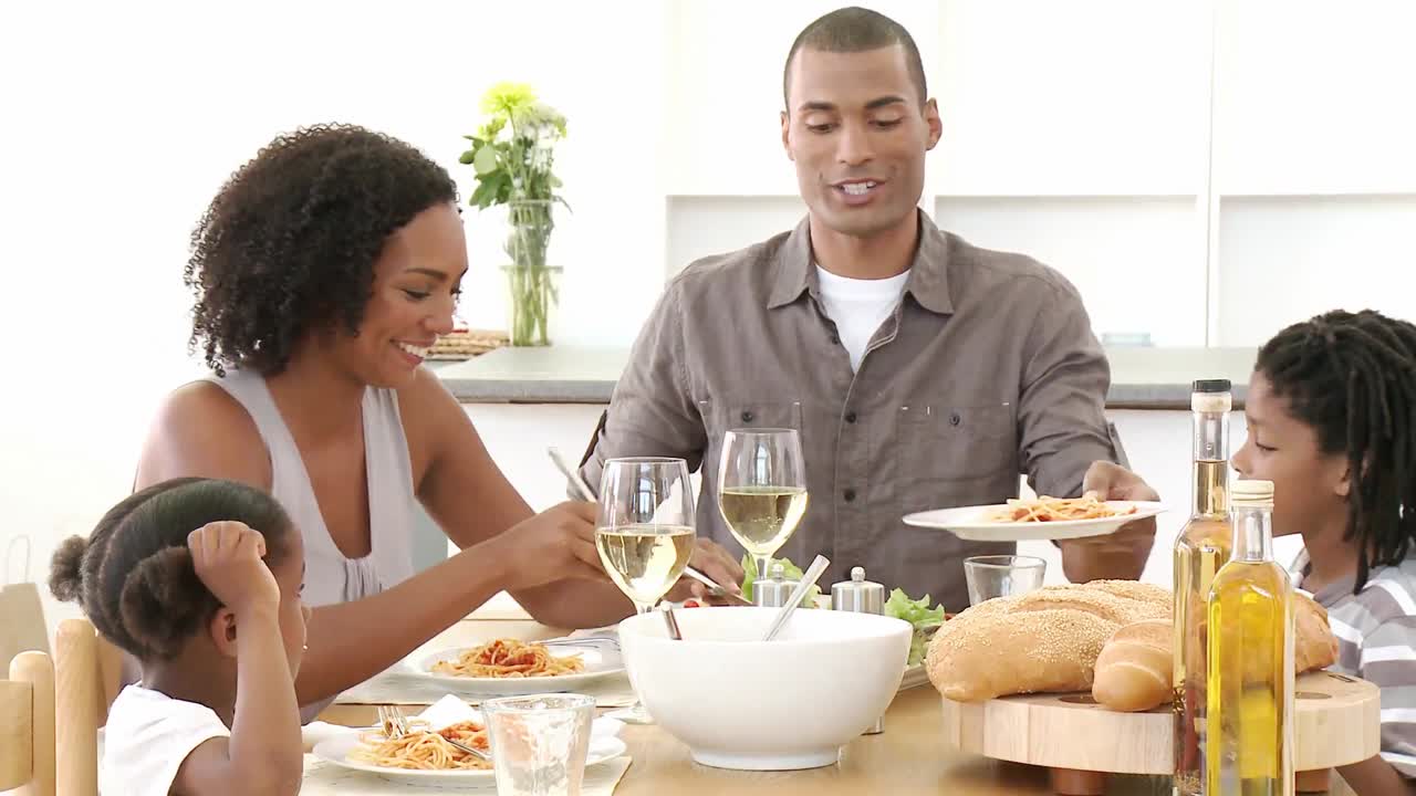 Family eating pasta and salad in the livingroom