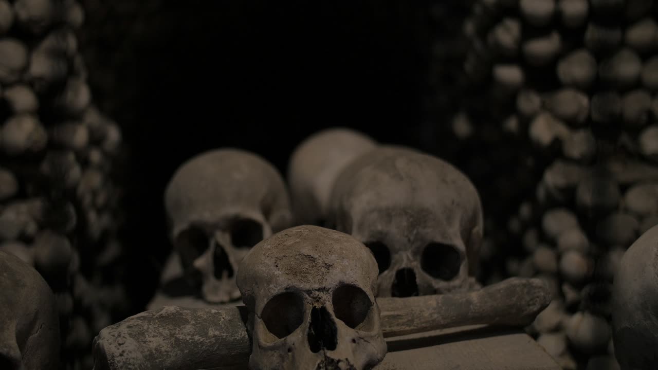 Push in shot through protective cage guarding human remains skull - bones in decorative spooky Sedlec Ossuary catholic Czech chapel.