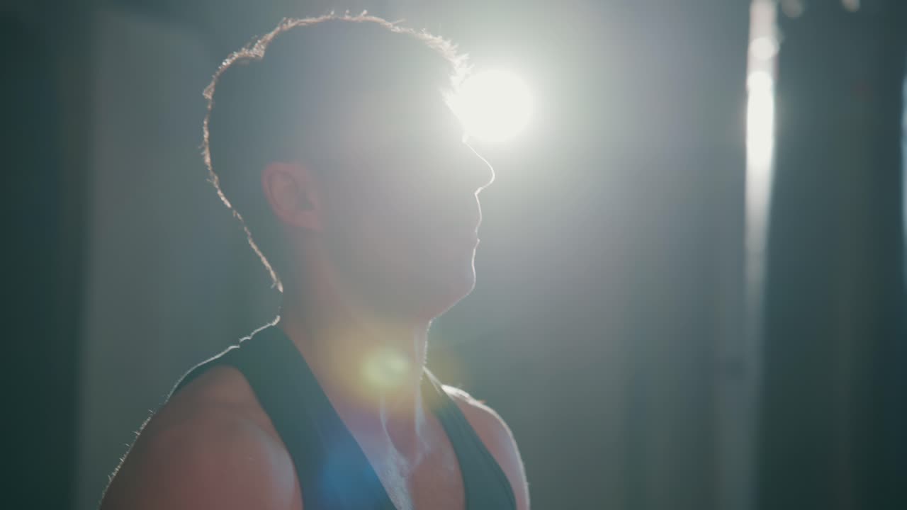 Atleta masculino cansado descansando y recuperándose después de un entrenamiento intenso en el gimnasio.
