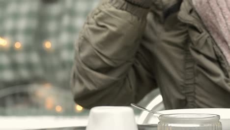 Woman-enjoying-hot-drink-on-street-cafe