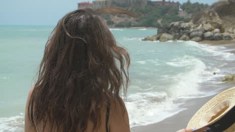 beautiful woman smiling on a beach with ocean in background