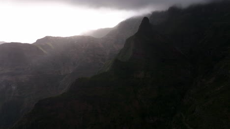 Vista-Aérea-Volando-Sobre-Montañas-Brumosas,-Con-Espectaculares-Nubes-Oscuras-En-Madeira