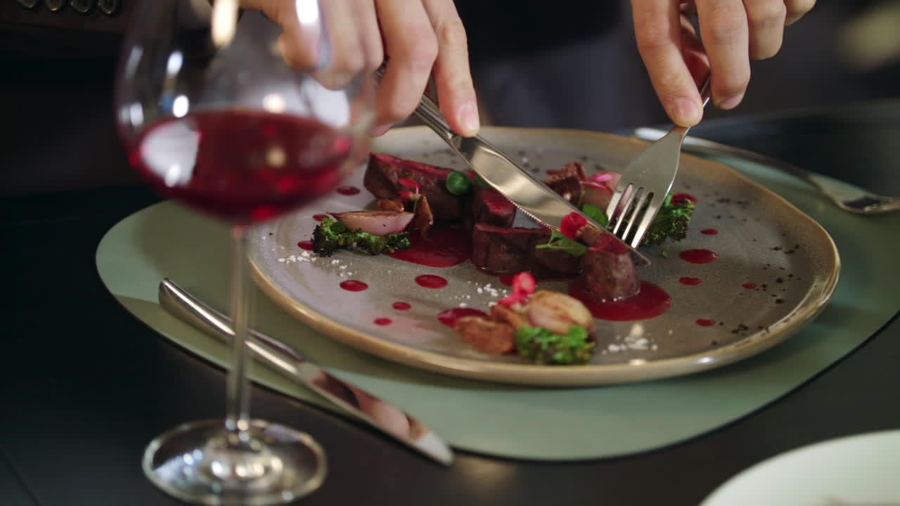 manos masculinas cortando filete de carne en un restaurante. hombre de negocios cenando en un restaurante