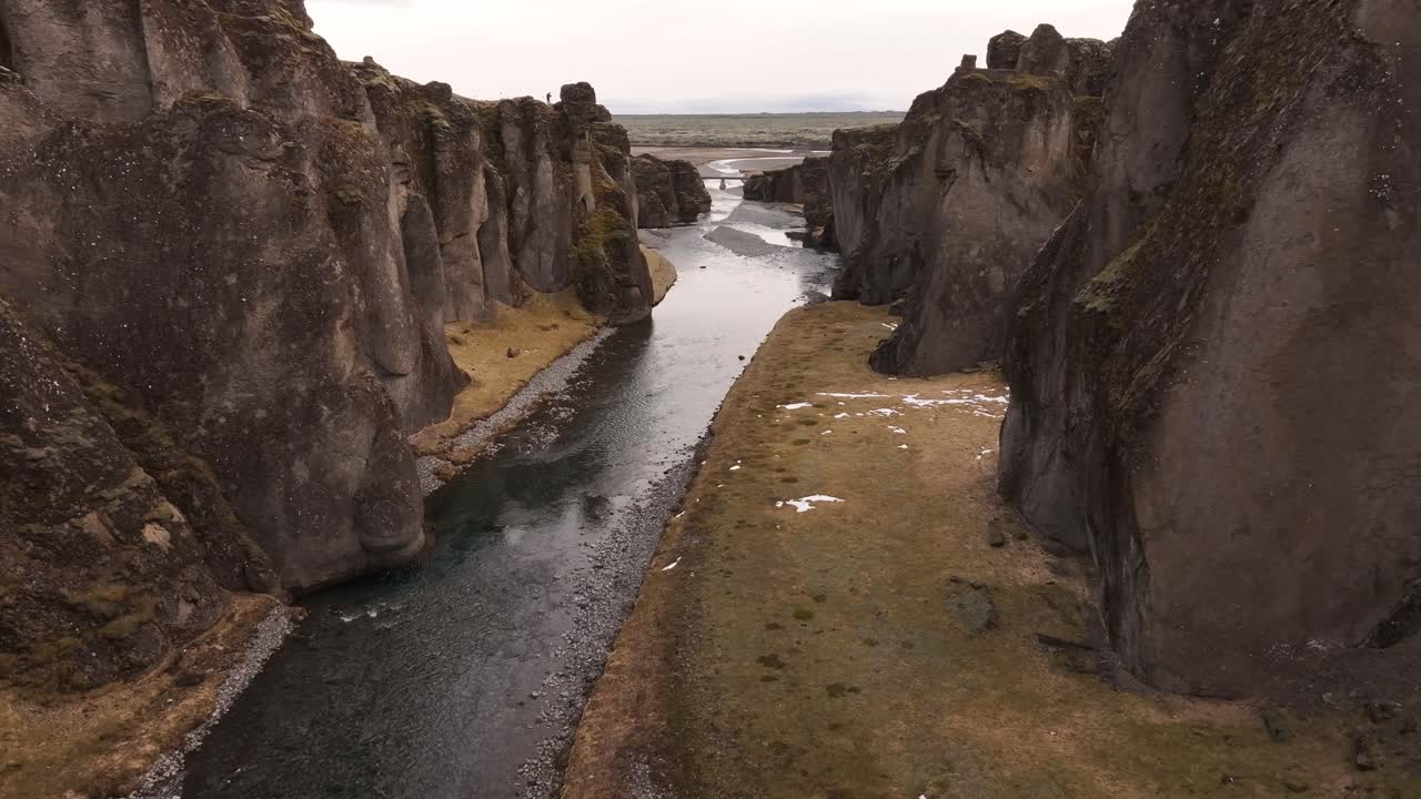 Iceland's Fjaðrárgljúfur Canyon - aerial drone view moving forward into canyon, cliffs, river valley and untouched natural beauty.
