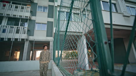 confident man walking city fence showcasing casual urban fashion. stylish zoomer