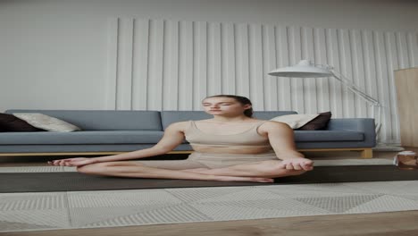 woman meditating in a yoga pose in her living room