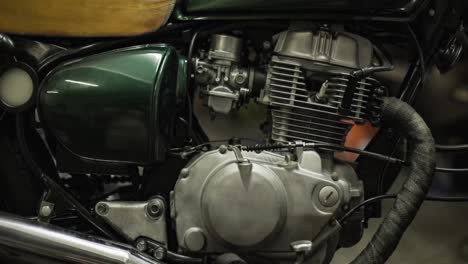 close up of engine, seat and fuel tank of classic retro green motorbike