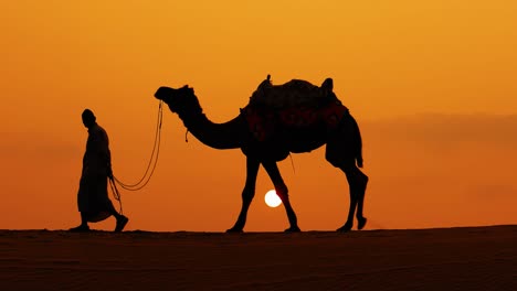 Cameleers,-camel-Drivers-at-sunset.-Thar-desert-on-sunset-Jaisalmer,-Rajasthan,-India.