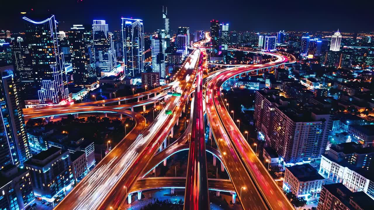 Aerial view of a vibrant cityscape at night with light trails, showcasing urban energy