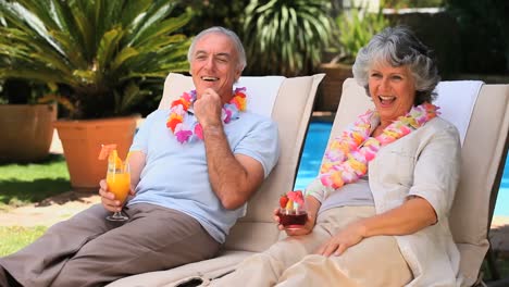 Pareja-De-Ancianos-Relajándose-En-Tumbonas