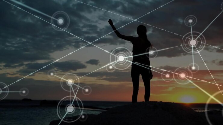 Woman reaching hand to rock at sunset, hauling upward to summit while tech network lines emerging