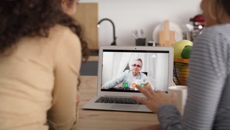 vista trasera de dos mujeres durante una videoconferencia con el padre