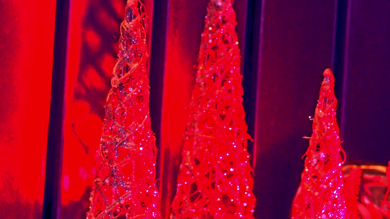 pequeños árboles de navidad decoran la habitación mientras que las luces azules de navidad brillan en la habitación